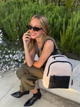 Mochila urbana de diseño combinado, confeccionada en tela resistente con bolsillo frontal y detalles en cuero sintético. Cuenta con compartimento principal con cierre y correas ajustables.