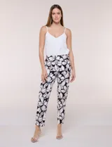 Pantalón de tiro alto de la marca Zac & Rachel, con corte cigarrete y silueta ajustada. Presenta pretina ancha elastizada sin cierres ni botones y un diseño sin bolsillos. Confeccionado con estampado floral en tonos blancos, negros y marrones.