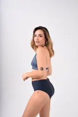 Conjunto de bikini con corpiño triangular con estampado abstracto en tonos violeta, rosa y negro, y bombacha tiro alto negra.