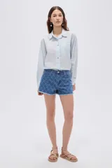 Short de jean azul con tiro alto, calce recto, bolsillos, diseño acolchado con rombos pespuntados y terminación desmechada en las piernas.