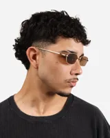 Lentes de sol con marco dorado y lentes marrones rectangulares.