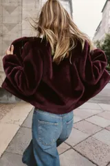 Chaqueta de cuello redondo y manga larga con tejido exterior efecto pelo e interior efecto ante. Presenta bolsillos delanteros de vivo y cierre frontal con alamares metálicos.