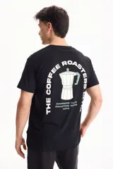 Remera negra de manga corta, confeccionada en algodón, con estampa en la espalda que presenta el texto "The Coffee Roasters Club" y el diseño de una cafetera moka.