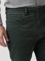 Pantalón de cotelé color verde oscuro con corte modern fit, cierre frontal con botón y bolsillos laterales.