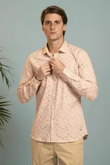 Camisa de manga larga en color salmón con estampado de pequeños motivos geométricos oscuros, cuello clásico y cierre frontal con botones.