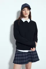 Sweater de punto color negro, con cuello redondo y diseño texturizado con ondas en relieve. Presenta mangas largas y un calce cómodo y holgado.