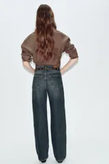 Jeans de tiro alto color azul claro, con cinco bolsillos y pernera recta que se estrecha hacia el tobillo. Incluye un cinturón negro con detalles metálicos. Cierre frontal con cremallera y botón.