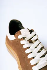 Championes urbanos de gamuza color bordó con suela de goma color caramelo y cordones blancos.