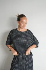 Pantalón negro de algodón y viscosa, con estampado de lunares blancos y corte holgado.