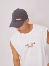 Gorra gris de poliéster y elastano, con visera curva y logo de Rusty en color naranja.