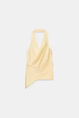 Top de tejido satinado con cuello halter y escote en pico cruzado. Presenta un diseño de espalda descubierta y bajo asimétrico con cierre lateral.