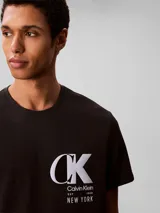 Remera de cuello redondo y manga corta, confeccionada en punto de algodón. Presenta un estampado gráfico en el pecho con el monograma de la marca y el texto New York.