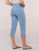 Pantalón capri en denim elastizado de calce entallado y estilo pull-on, color azul. Presenta cintura ancha totalmente elastizada, bragueta simulada, bolsillos delanteros redondeados con remaches metálicos, canesú anatómico y bolsillos traseros plaqué.