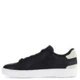 Championes urbanos Puma Serve Pro, color negro con detalles en gris y logo dorado, confeccionados en cuero sintético con suela blanca.