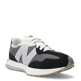 Championes urbanos New Balance modelo 327, con diseño retro que combina paneles de gamuza negra y malla gris. Presenta el logo 'N' sobredimensionado en color gris claro en el lateral, cordones blancos y una suela de goma con relieve que se extiende hacia el talón.