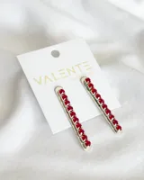 Aros colgantes plateados con strass rojos en forma de corazón.