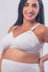 Soutien maternal de gran cobertura, color blanco, confeccionado en tela reforzada sin aro. Presenta escote alto, clip para lactancia, breteles elásticos regulables y cierre con broches en la espalda.