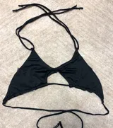 Top de bikini negro con escote triangular y tiras finas ajustables.