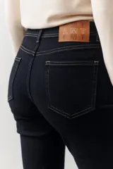 Pantalón marrón de corte recto con cinturón de cuero marrón con hebilla metálica.