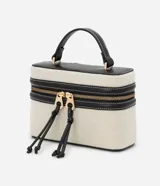 Cartera pequeña tipo bandolera de la marca Satinato, color beige con detalles en negro, confeccionada en una mezcla de algodón y poliuretano con forro de poliéster. Cuenta con tapa con doble cierre, cordón decorativo, asa de mano y correa larga removible.