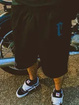 Bermuda color beige de gabardina de algodón con cintura elástica, corte amplio y bordado con logo en una pierna.