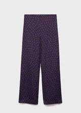 Pantalón de tiro medio con diseño flare y largo, con cierre de cremallera lateral y estampado de lunares.