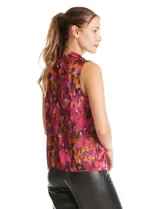 Blusa sin mangas de satén con estampado abstracto en tonos fucsia, rosa, naranja y negro. Presenta cuello alto con detalle de nudo frontal y cierre de botón en la espalda.