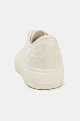 Zapatillas deportivas color crema con bordados florales. Cierre con cordones y punta redonda.