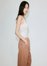 Jeans de corte recto y tiro medio con diseño de rayas verticales en tonos marrón y blanco.