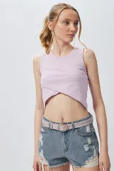 Musculosa corta negra sin mangas, de corte asimétrico frontal y ceñida al cuerpo.