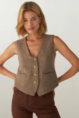 Chaleco marrón de lana con escote en V y cierre con botones.