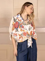 Camisa de seda color crema con estampado floral multicolor, cuello clásico y mangas 3/4 abullonadas.