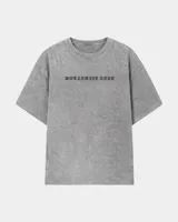Remera oversize gris con efecto acid wash y estampa frontal con la leyenda "WORLDWIDE TOUR" en tipografía gótica.
