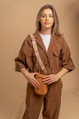 Phonebag de diseño compacto y moderno, color plateado, con cierre frontal y correa ajustable y desmontable con diseño geométrico. Cuenta con logo grabado en el frente.