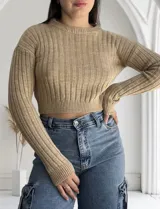Sweater tejido de punto color beige, con cuello redondo y mangas largas.