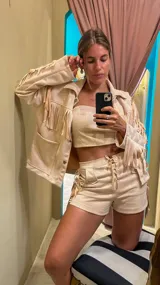 Campera color beige de gamuza sintética con flecos en mangas, espalda y ruedo.