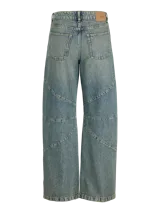 Jean wide fit de tiro medio, pierna curva y corte relajado, confeccionado en denim con lavado desgastado y costuras decorativas segmentadas.