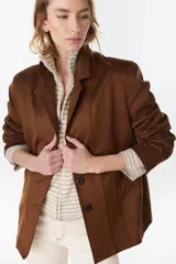 Chaqueta marrón de gamuza sintética con solapas, cierre frontal de botones y bolsillos laterales.