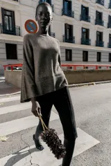 Jersey de punto color marrón oscuro con lentejuelas plateadas, cuello barco y manga larga acampanada.