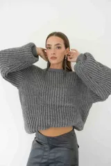 Sweater de punto grueso color gris, con cuello redondo y mangas anchas.