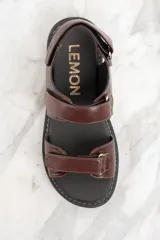 Sandalias marrones de cuero con suela de goma negra y ajuste con velcro.