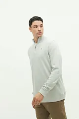 Buzo de felpa diferenciada color verde claro, con medio cierre frontal y cuello alto. Presenta logo en goma en el pecho y corte regular.