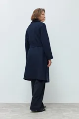 Tapado de paño azul marino, con solapas clásicas, corte recto y largo por debajo de la rodilla.