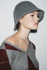 Gorro tipo bucket confeccionado en hilatura de lana, con diseño minimalista y textura suave.