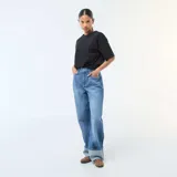 Jean de corte regular y cintura alta, confeccionado en denim azul con lavado stonewash. Presenta un diseño de pierna recta con un dobladillo ancho en la parte inferior.