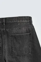 Jeans de hombre, corte balloon fit, tiro medio, confeccionados en denim rígido de algodón. Presentan un efecto lavado con un marcado degradado vertical, cinco bolsillos y cierre frontal con cremallera y botón.