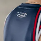 Musculosa de básquet Umbro del Club Nacional de Football, modelo Alternativa. Diseño azul con detalles en blanco y rojo en cuello y sisas. Incluye logo de Umbro, escudo del club y sponsor en el frente.