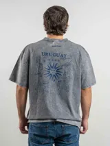 Remera de corte oversize color marrón con efecto lavado, cuello redondo y estampa frontal con la frase 'URUGUAY noma!'.
