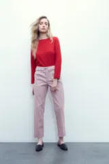 Pantalón rosa pastel con cintura elastizada, bolsillos laterales y cinto con hebilla metálica.