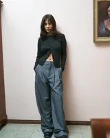 Pantalón sastrero gris de corte ancho con pinzas en la cintura y bolsillos laterales.